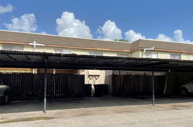 covered parking lot featuring fence