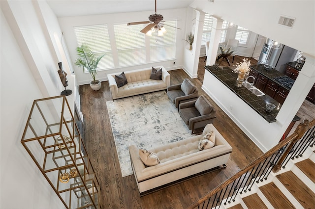 living room featuring hardwood / wood-style flooring, ceiling fan, and sink