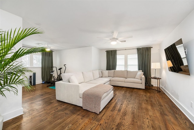 living room with ceiling fan and dark wood-type flooring