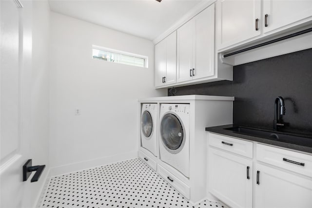 laundry area with cabinets, independent washer and dryer, and sink