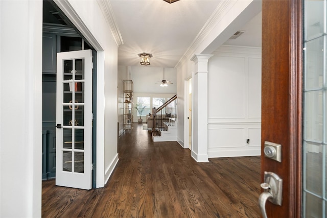 hallway with dark hardwood / wood-style flooring, ornamental molding, and decorative columns