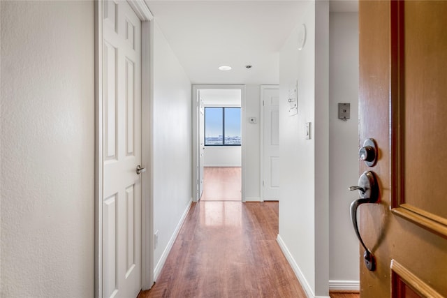 corridor with hardwood / wood-style flooring