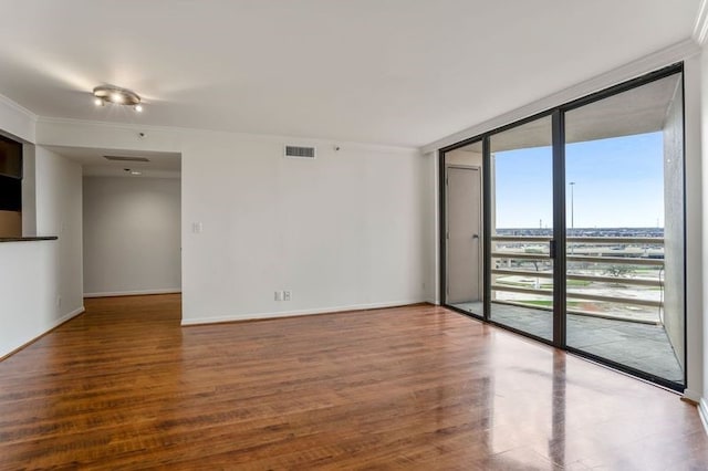 unfurnished room featuring crown molding, wood-type flooring, and a wall of windows