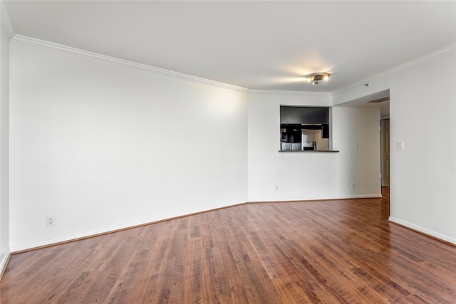 unfurnished room featuring dark wood-type flooring and crown molding