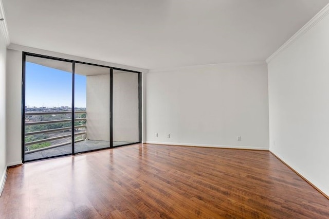 spare room with a wall of windows, crown molding, and wood-type flooring