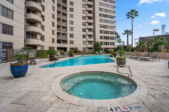 view of swimming pool featuring a patio area and a community hot tub