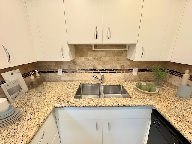 kitchen featuring dishwasher, tasteful backsplash, white cabinets, and a sink