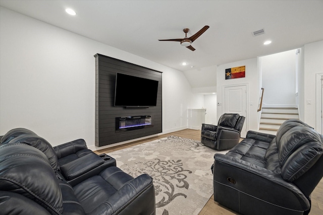 living room featuring a fireplace, light hardwood / wood-style flooring, and ceiling fan