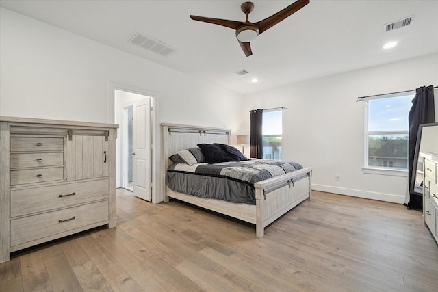 bedroom with multiple windows, light hardwood / wood-style flooring, and ceiling fan