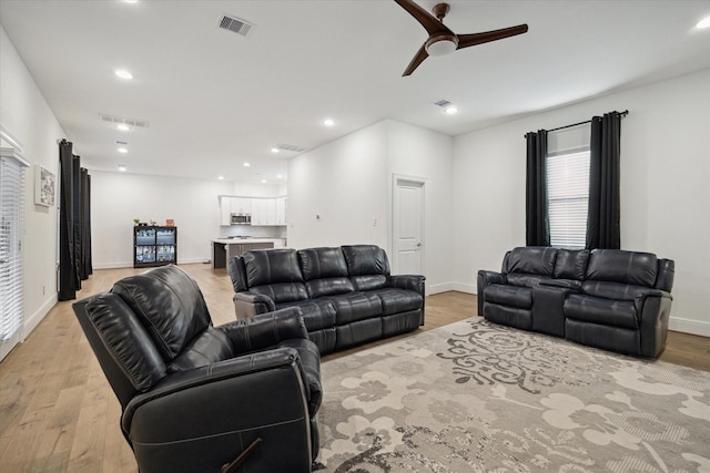 living room with ceiling fan and light hardwood / wood-style floors