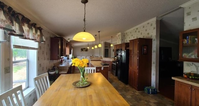 dining room with wallpapered walls, ornamental molding, and a textured ceiling