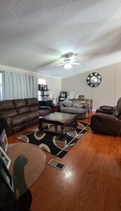 living room featuring a ceiling fan, a textured ceiling, and wood finished floors