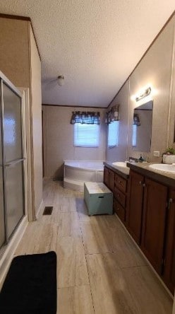 full bath with wood finished floors, a garden tub, a textured ceiling, vanity, and a shower stall