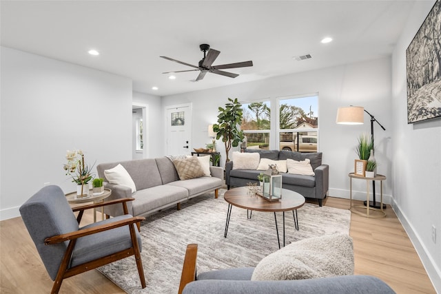 living room featuring light hardwood / wood-style flooring and ceiling fan