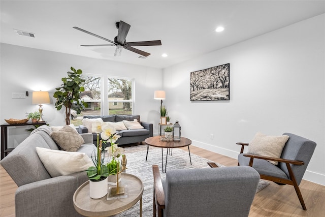 living room with light hardwood / wood-style floors and ceiling fan