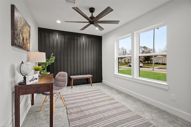 carpeted office space featuring ceiling fan