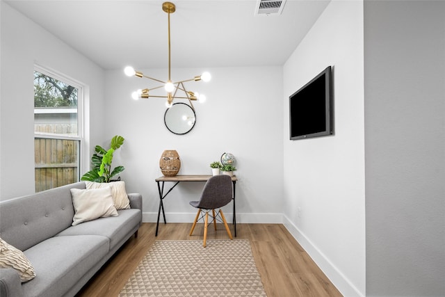 home office featuring light hardwood / wood-style floors and a notable chandelier