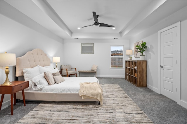 carpeted bedroom with a raised ceiling and ceiling fan