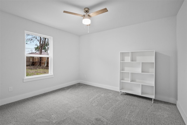 carpeted spare room with ceiling fan