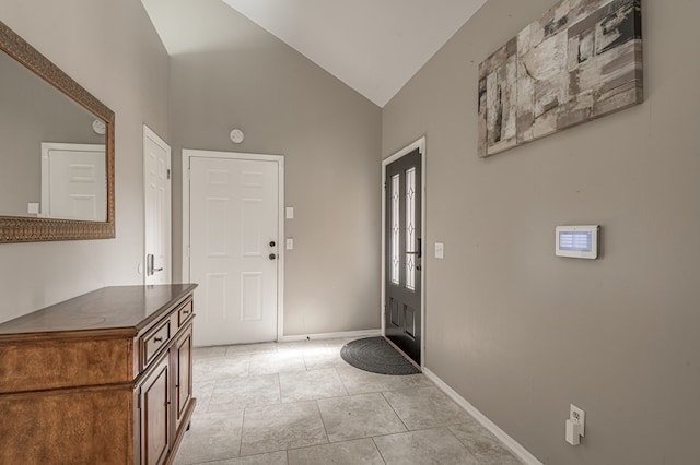 entrance foyer featuring lofted ceiling and light tile patterned flooring