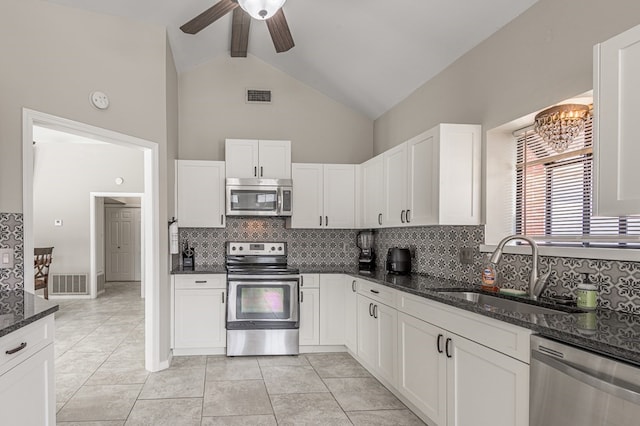 kitchen with white cabinets, dark stone countertops, appliances with stainless steel finishes, and sink