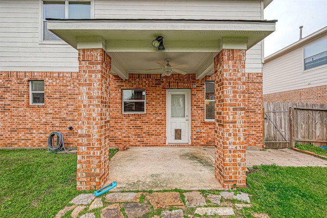 doorway to property featuring a patio area, a yard, and ceiling fan