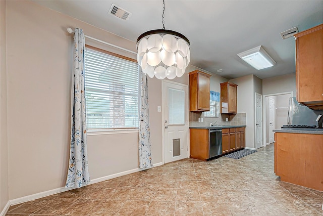 kitchen featuring appliances with stainless steel finishes, tasteful backsplash, decorative light fixtures, sink, and an inviting chandelier