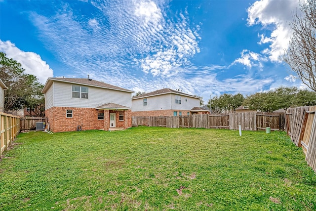 rear view of property with a yard and central AC unit