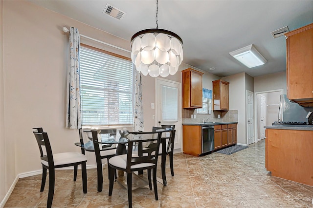 kitchen with appliances with stainless steel finishes, backsplash, a chandelier, and decorative light fixtures