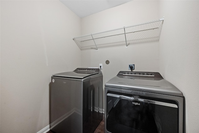 laundry area with laundry area, baseboards, and washing machine and clothes dryer