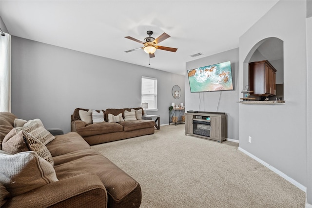 living area with carpet floors, ceiling fan, visible vents, and baseboards