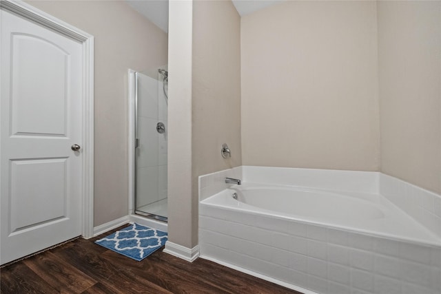 full bath featuring a garden tub, a stall shower, and wood finished floors