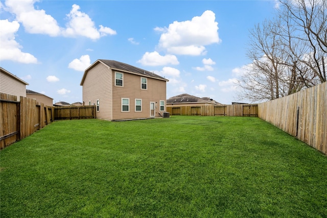 view of yard featuring a fenced backyard and central AC