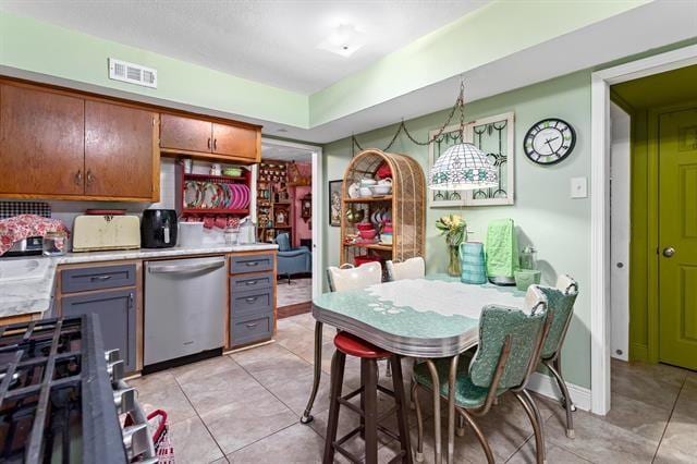 kitchen featuring sink, hanging light fixtures, stainless steel appliances, and light tile patterned floors