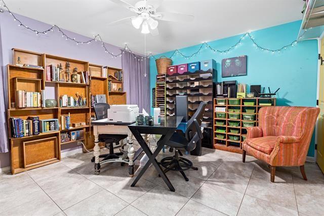 tiled office space featuring ceiling fan