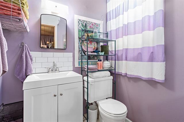 bathroom with backsplash, vanity, and toilet