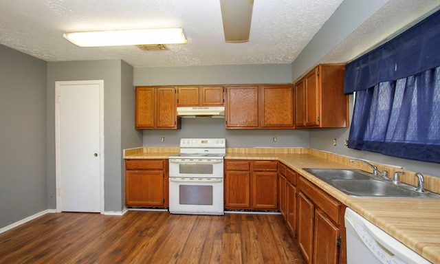 kitchen with white appliances, sink, dark wood-type flooring, and a textured ceiling