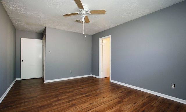 empty room featuring dark hardwood / wood-style flooring, ceiling fan, and a textured ceiling