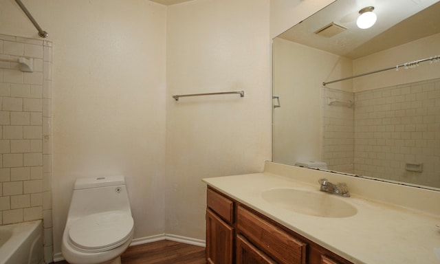 full bathroom with toilet, vanity, tiled shower / bath, and wood-type flooring