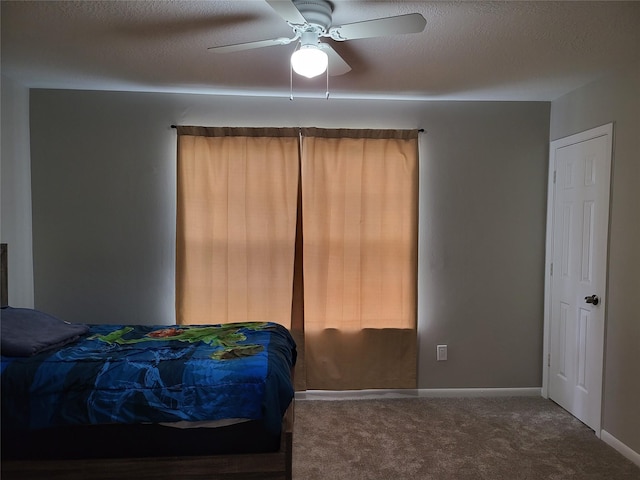 carpeted bedroom with ceiling fan and a textured ceiling