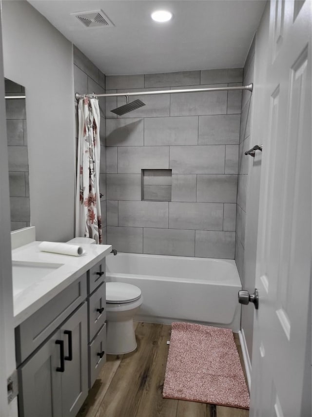 full bathroom featuring vanity, toilet, shower / bathtub combination with curtain, and hardwood / wood-style floors