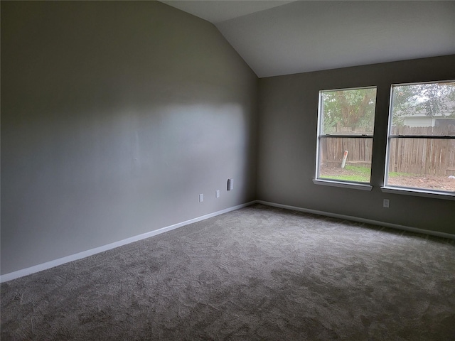 carpeted empty room featuring lofted ceiling