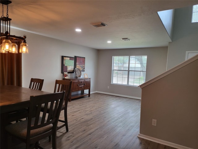 dining area featuring hardwood / wood-style flooring and an inviting chandelier