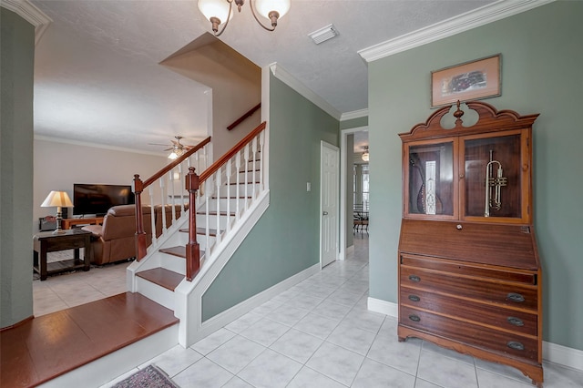 entryway featuring ceiling fan with notable chandelier, ornamental molding, and light tile patterned flooring