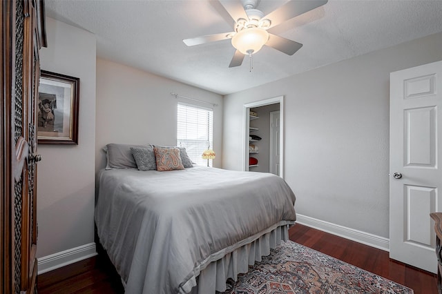 bedroom with ceiling fan, dark hardwood / wood-style floors, and a textured ceiling