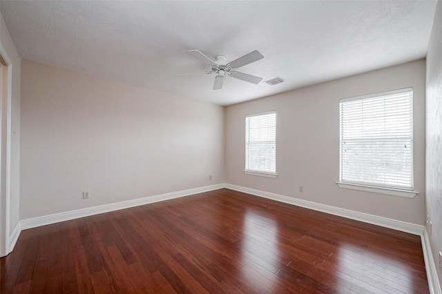 empty room featuring ceiling fan and dark hardwood / wood-style flooring