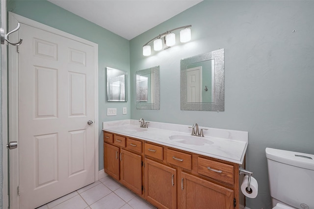 bathroom with toilet, vanity, and tile patterned flooring