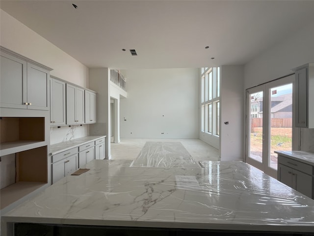 4410 Southpoint Way S, Fulshear, TX 77441 - kitchen featuring a center island, light stone countertops, and gray cabinets