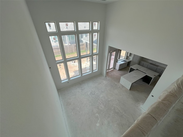 4410 Southpoint Way S, Fulshear, TX 77441 - unfurnished living room with unfinished concrete floors and a high ceiling