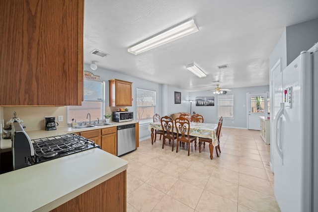 kitchen with ceiling fan, appliances with stainless steel finishes, sink, and light tile patterned floors